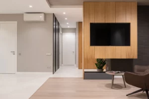 a living room with a tv mounted on ta custom woord furniture