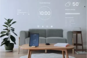 A digital tablet computer sitting on a coffee table in a living room. The tablet is black and has a home automation system showing on the the screen