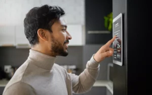 Man in a Kitchen using a tablet for controlling a home automation app.