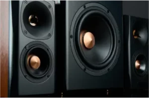 Close-up photo of a pair of black speakers with silver cones and grilles.
