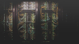 A row of black server racks arranged in a line, with colorful cables connecting them.