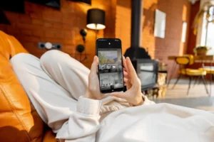 Woman holding a phone with a smart home savant systems app